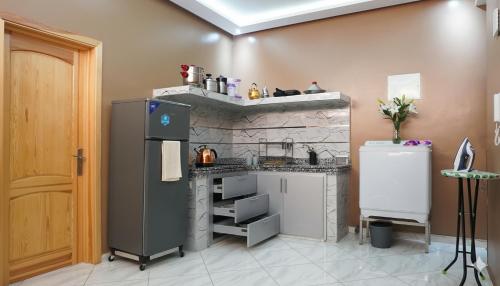 a kitchen with a refrigerator and a stone wall at Hotel America Apartments in Dakhla