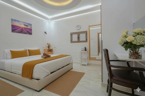 a bedroom with a bed and a table with a vase of flowers at Hotel America Apartments in Dakhla