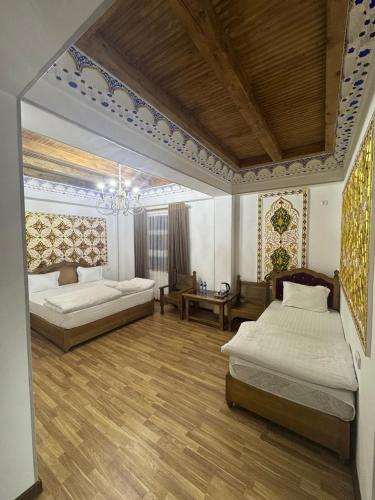ein Schlafzimmer mit zwei Betten und einem Kronleuchter in der Unterkunft Central asia hotel in Muruntau
