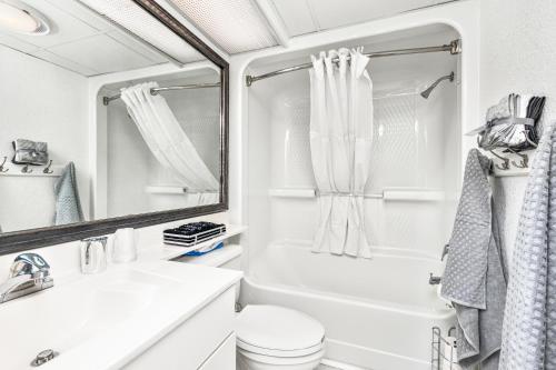 um banheiro com banheira, vaso sanitário e pia em A Caribbean Oasis at SeaWatch em Myrtle Beach