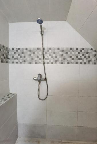 a shower with a shower head in a bathroom at Relax House in Ikhorbane