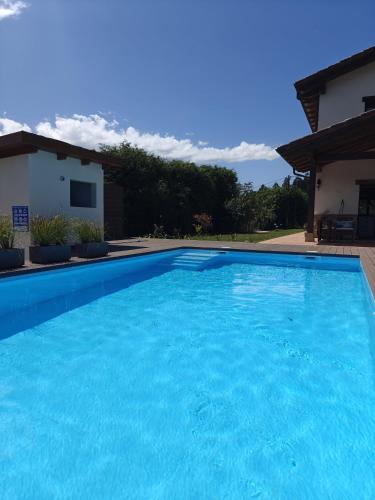 a large blue swimming pool in front of a house at Casa Eloy in Argüero