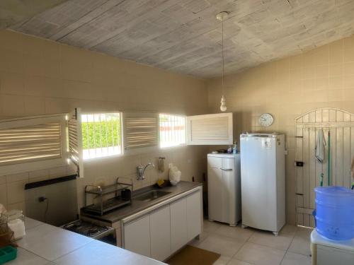 a kitchen with a sink and a white refrigerator at Casa em Itamaracá - 70 metros da Praia in Itamaracá