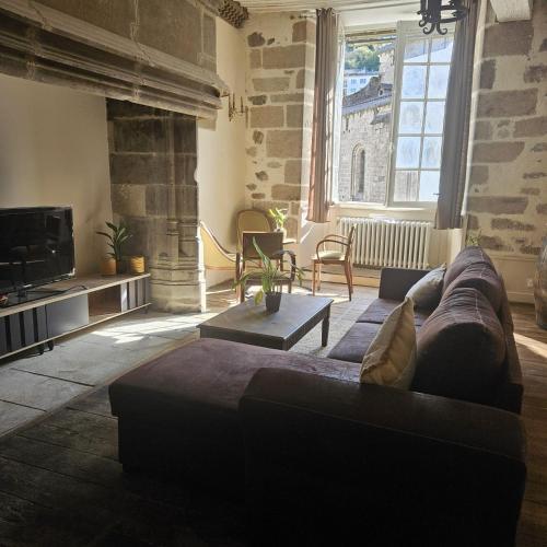 a large living room with a couch and a tv at Gite Maison Loyac in Tulle