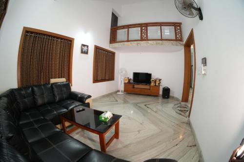 una sala de estar con un sofá y una mesa en The Kayal Delight, en Cheruvattūr