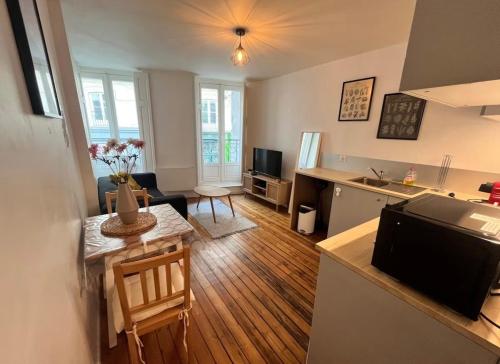 a kitchen and a living room with a table and a kitchen and a living room at Pilori 2 pers, separate bedroom, Tv wifi in Nantes