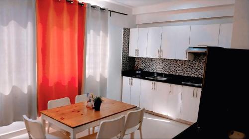 eine Küche mit einem Holztisch und weißen Schränken in der Unterkunft Beach Lounge Punta Cana Aparthotel 1 in Punta Cana