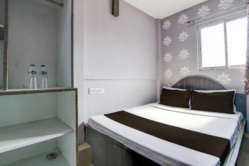 a small bed in a small room with a window at Hotel O Sharan Guest House in Calcutta Bara Bazar
