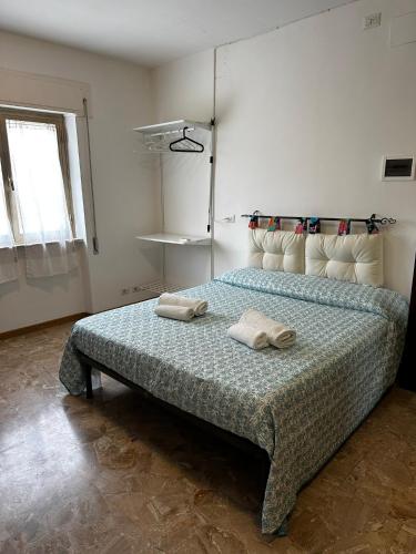 a bedroom with a bed with two towels on it at La casa di Elvis in Ladispoli