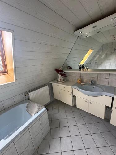 a bathroom with a tub and a sink at Large Room Near The train station and highway in Schnaittach