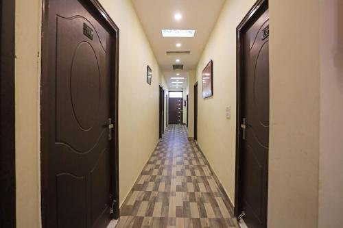 a hallway with two brown doors and a tile floor at Super Hotel O Raj Palace in Meerut