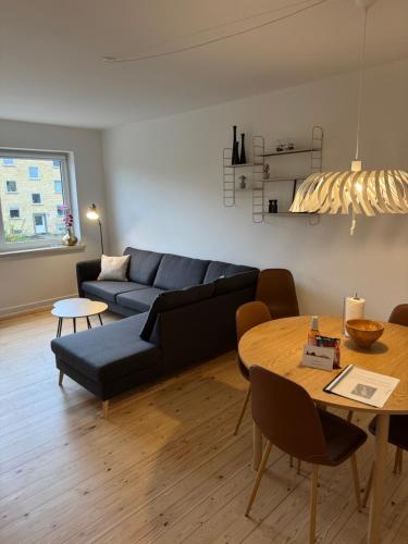 a living room with a couch and a table at Flot 3 værelses lejlighed - op til 6 personer in Randers
