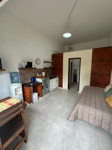 a large room with a kitchen with a table at Alojamiento De Rocha in Monte Grande