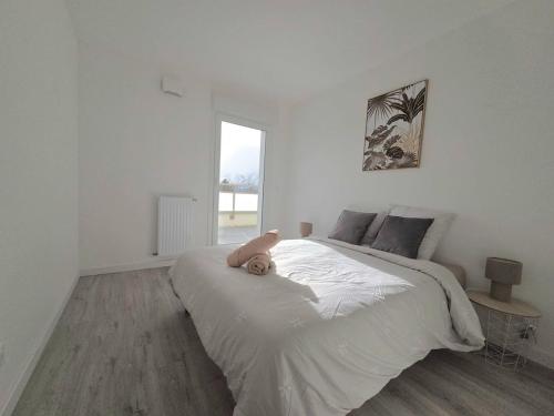 ein Stofftier, das auf einem Bett in einem Schlafzimmer liegt in der Unterkunft Le Chaleureux in Annemasse