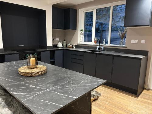 a kitchen with black cabinets and a black counter top at Cottage in Holmfirth Centre in Holmfirth