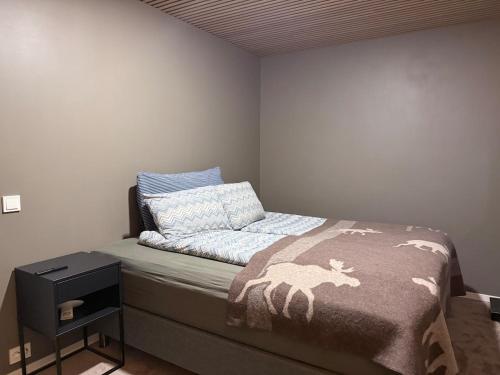 a small bedroom with a bed and a night stand at Luxury Panorama Apartment by the Sea with Northern Lights View in Tromsø