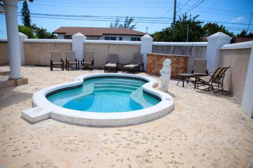 a swimming pool with a statue next to a patio at Tangerine Sunsets Satsuma One in Nassau