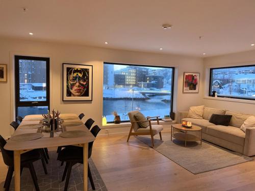 a living room with a couch and a table at Luxury Panorama Apartment by the Sea with Northern Lights View in Tromsø