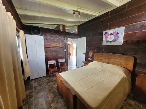 a bedroom with a bed and a wooden wall at Cabaña Elun in Panaholma