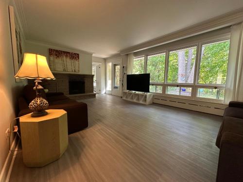 a living room with a couch and a table with a lamp at Modern Private Room with Bessarion Subway North York in Toronto
