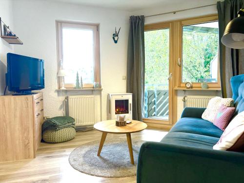a living room with a blue couch and a table at Fewo Herzgrün nähe Skilift & Loipe mit Sauna im Haus und Traumblick E-Ladestation in Todtnauberg