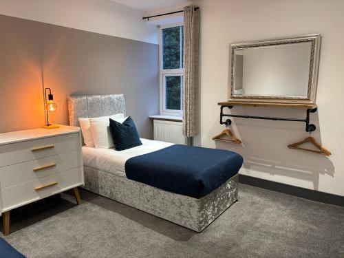 ein Schlafzimmer mit einem Bett mit Spiegel und einer Kommode in der Unterkunft Cottage in Holmfirth Centre in Holmfirth