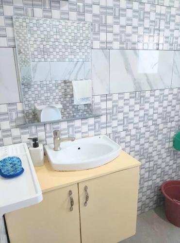 a bathroom with a sink and a mirror at Residence Merveilles CM15 in Kribi