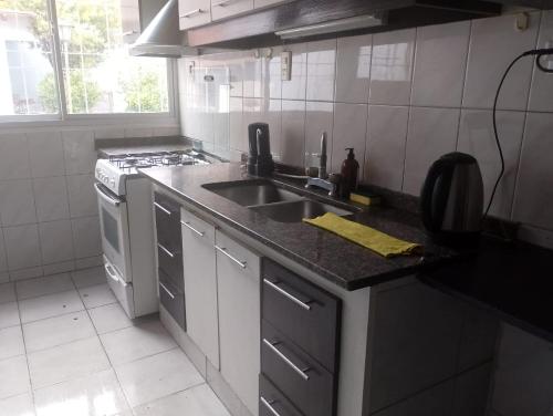 eine Küche mit Spüle und Herd in der Unterkunft Casa y departamento en mismo domicilio para 10 personas in Barraquero