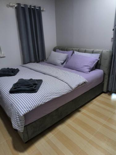 a bed with purple pillows in a room at Baan Boy in Ko Kood