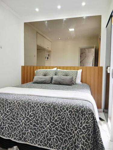 a bedroom with a large bed with a wooden headboard at Apart 3qtrs á 1200m da praia de Itapuã in Vila Velha