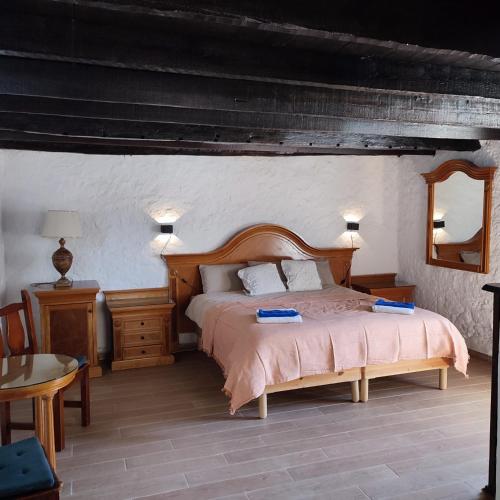 a bedroom with a large bed with a wooden headboard at El Caserio de Araña - Atlantic Blue Ocean in Los Cercados