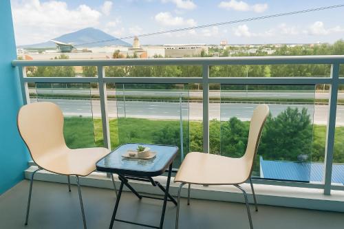 two chairs and a table on a balcony with a view at Tala Haven at Azure North Studio with Mt Arayat View in San Fernando