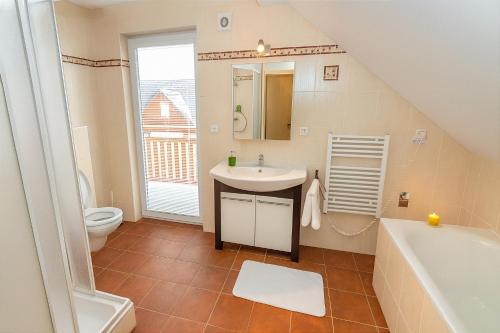 Un baño con lavabo, inodoro y bañera. en Villa Slupečná, en Lipno nad Vltavou