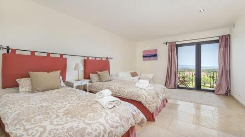 ein Schlafzimmer mit zwei Betten und einem großen Fenster in der Unterkunft SainteMaxime PremiumVilla PrivatePool in Sainte-Maxime