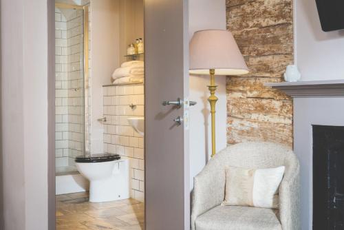 een badkamer met een stoel en een toilet bij The Globe in Exeter