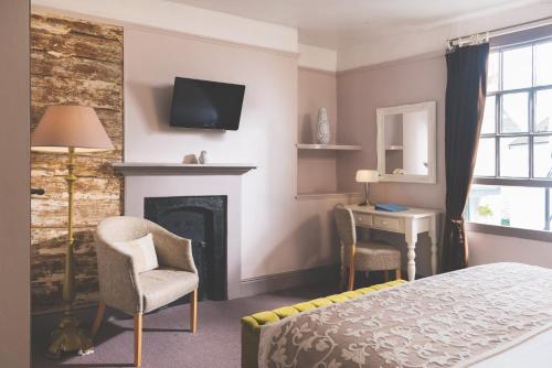 a bedroom with a bed and a fireplace and a television at The Globe in Exeter