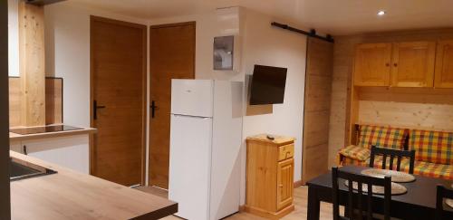 a kitchen with a white refrigerator and a table at Chez Mat in Lans-en-Vercors