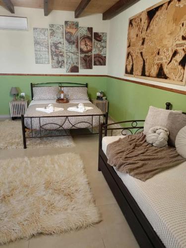 two beds in a room with green walls and rugs at Sofilia view house in Argilia