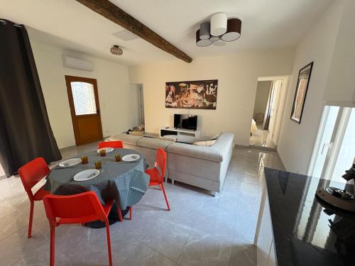 un salon avec une table, des chaises et un canapé dans l'établissement Superbe maison d artiste avec patio centre ville, à Sète