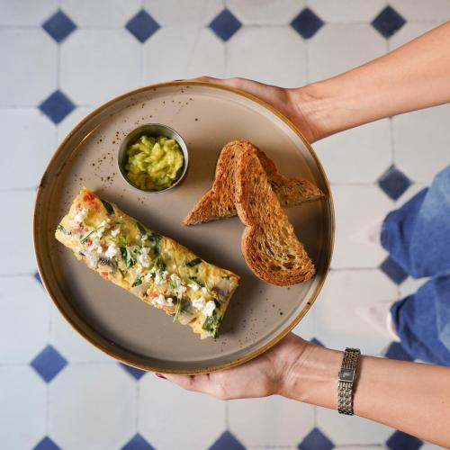a person holding a plate with slices of pizza and toast at B Haus Hotel Boutique in Cartagena de Indias