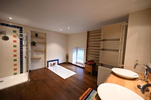 a bathroom with two sinks and a shower in a room at Le Nid d'à côté in Méan