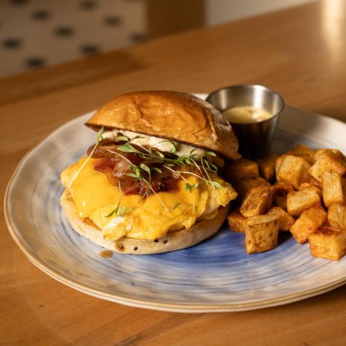 a breakfast sandwich and french fries on a plate at B Haus Hotel Boutique in Cartagena de Indias