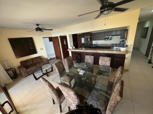 une salle à manger et un salon avec une table et des chaises dans l'établissement Departamento frente al mar con alberca, à Telchac Puerto