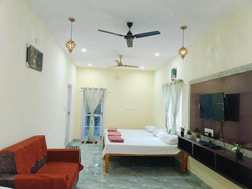 ein Wohnzimmer mit Sofa und Fernseher in der Unterkunft Pure Vegeterian 1BHK Private Guest House - Air Cnditioned - WiFi - Full Kitchen - No Alcohol Zone - Hilltop Heaven in Yelagiri