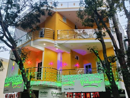 ein gelbes Haus mit einem Balkon davor in der Unterkunft Pure Vegeterian 1BHK Private Guest House - Air Cnditioned - WiFi - Full Kitchen - No Alcohol Zone - Hilltop Heaven in Yelagiri