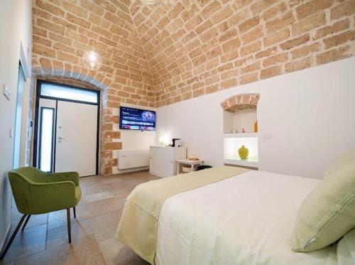 a bedroom with a large bed and a brick wall at SuiteLab in Palo del Colle