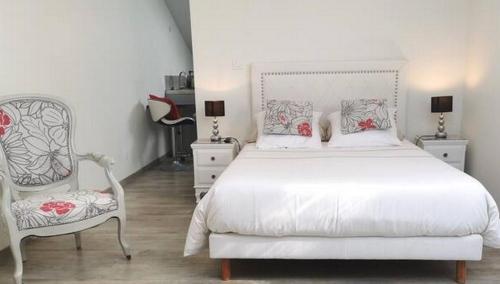 a bedroom with a white bed and a chair at Studios MISTRAL21 en Camargue in Salin-de-Giraud
