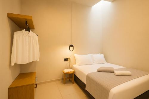 a small bedroom with a bed and a dresser at Mirthea Suites in Mírthios