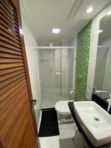 a bathroom with a shower and a toilet and a sink at Próximo a praia das castanheiras, internet, cooler, cadeiras de praia,roupas de cama e banho in Guarapari