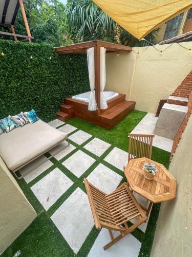a patio with a table and chairs and a gazebo at Privada cerca de playa con Jacuzzi, BBQ y Terraza in Cancún